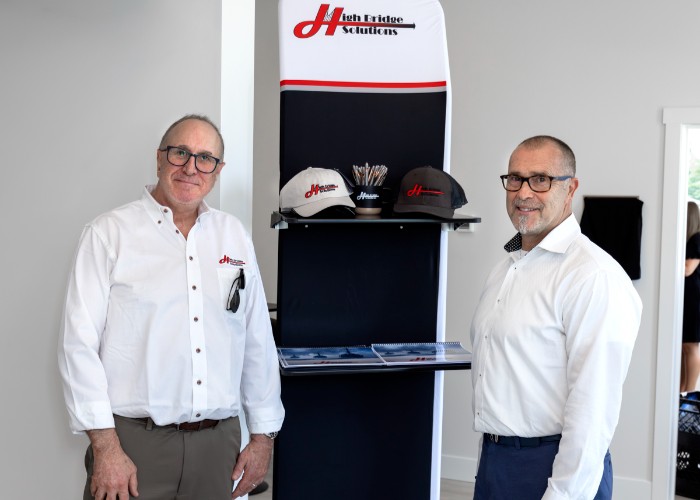 Two men standing by branded hat display
