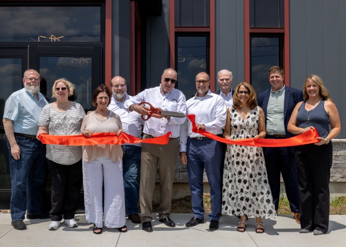 Group ribbon-cutting ceremony outside new building