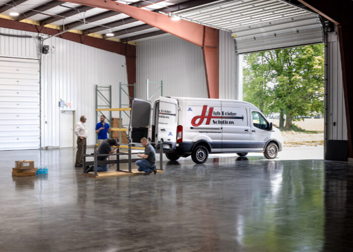 Service van and crew building warehouse shelving
